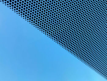Low angle view of blue sky seen through metal