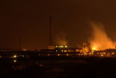 Illuminated city against sky at night