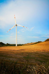 Windmill on field against sky