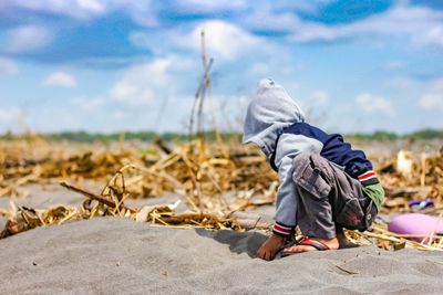 Rear view of man on field against sky