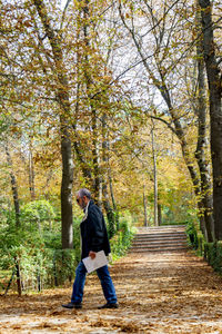 Full length of man standing on footpath in forest