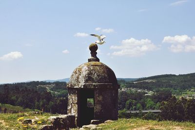 View of cross on land against sky