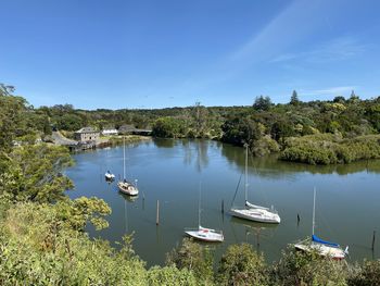 Sailboats moored in lake against sky