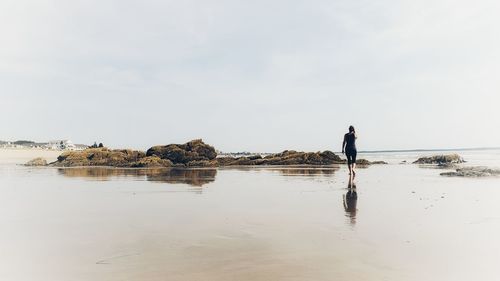 Man standing on beach against sky