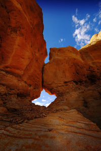 Low angle view of eroded red rocky structure