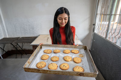 Portrait of smiling young woman standing in kitchen