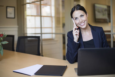 Businesswoman talking on phone in office