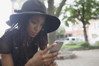 Midsection of young woman using mobile phone