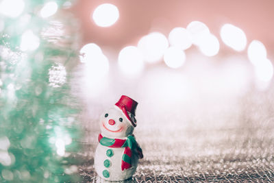 Close-up of figurine with toy on snow