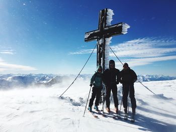 People on snowcapped mountain against sky during winter