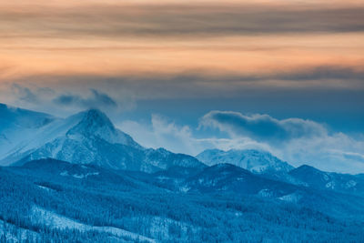 Scenic view of snowcapped mountains against sky during sunset