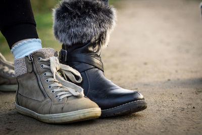 Low section of person wearing shoes on footpath