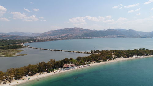 Scenic view of sea by mountains against sky