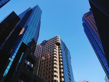 Low angle view of modern buildings against blue sky