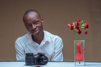 Portrait of young man sitting on table