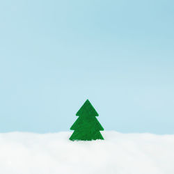Green christmas tree on blue background with fake snow. high quality photo