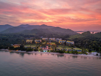 Scenic view of sea and mountains against sky during sunset