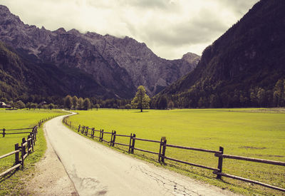 Road leading towards mountains against sky