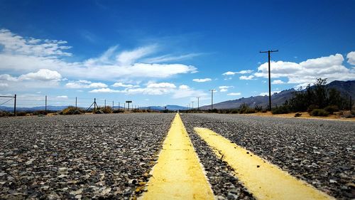 Empty road against cloudy sky