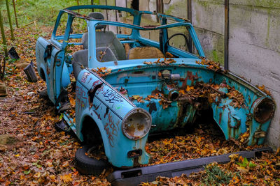 High angle view of abandoned car on field in forest