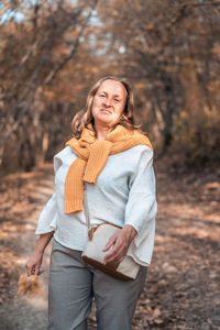 Portrait of a smiling young woman standing during autumn