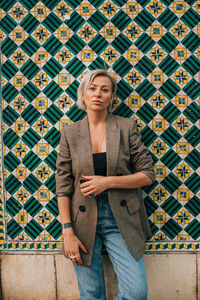 Portrait of woman standing against wall