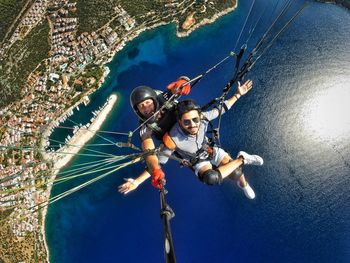 High angle view of people paragliding over sea