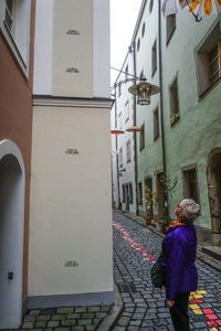 Woman standing by building in city