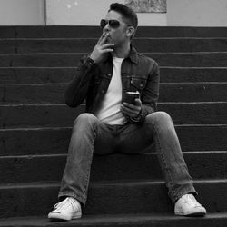 Man smoking while sitting on steps