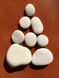 High angle view of pebbles arranged on brown surface