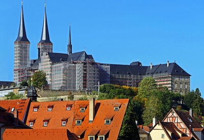 Panoramic view of buildings in city against clear blue sky