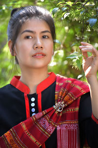 Close-up portrait of woman touching plant