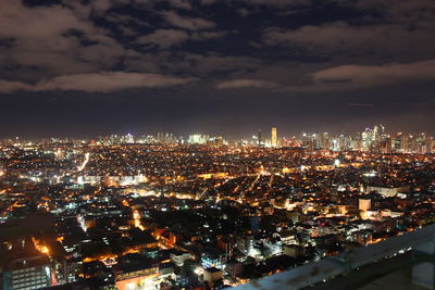 High angle view of illuminated cityscape against sky at night