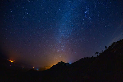 Low angle view of silhouette mountain against sky at night