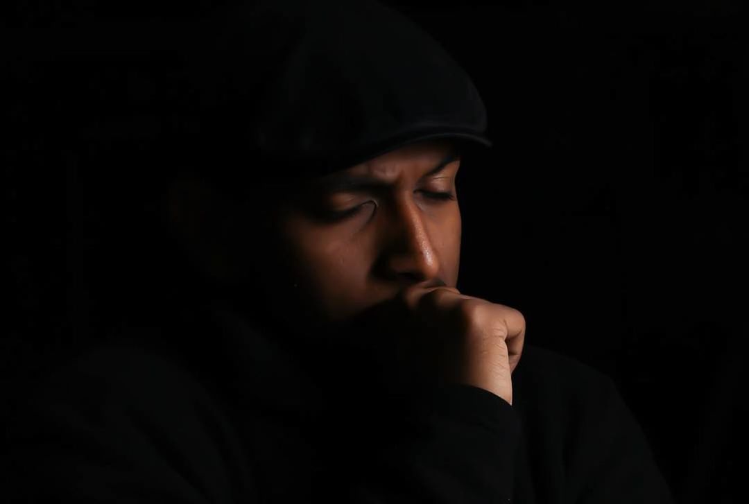 CLOSE-UP PORTRAIT OF A SERIOUS YOUNG MAN WITH SHADOW