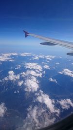 Aerial view of airplane wing over clouds