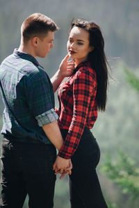 Loving young couple standing in forest