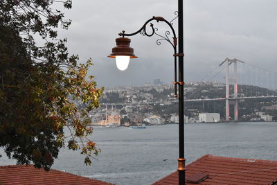 Street light by buildings against sky