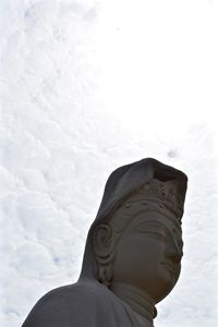Low angle view of statue against sky during winter