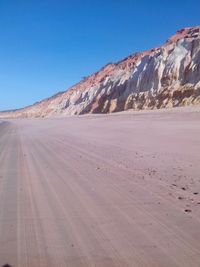 Scenic view of desert against clear blue sky