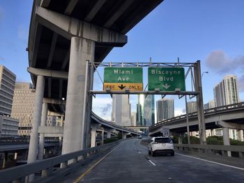 Road sign on bridge against sky in miami