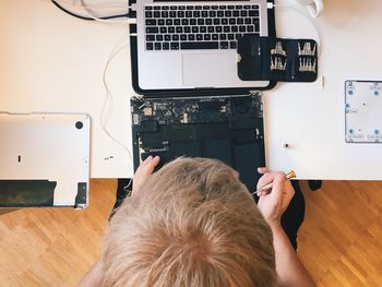 Cropped image of engineer repairing laptop at table