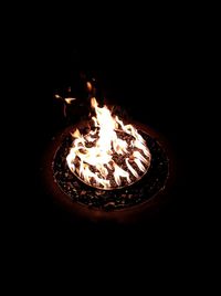 Close-up of illuminated lamp over black background