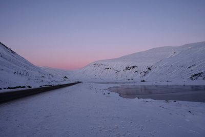 Scenic view of snowcapped mountains against clear sky during winter