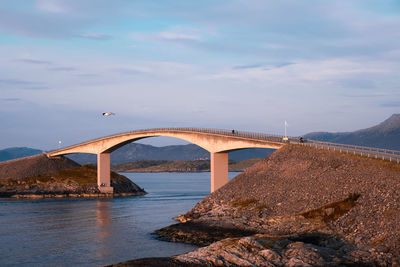 Arch bridge over river against sky