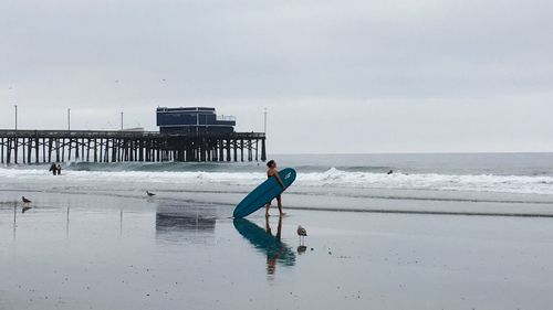 Man standing on beach against sky