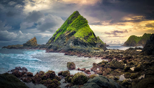 Scenic view of rocks on sea against sky