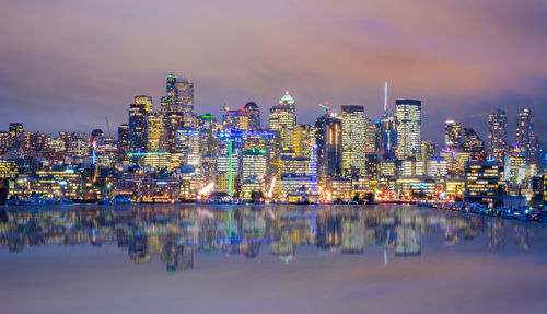 Illuminated buildings in city against sky at night