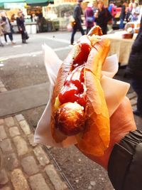 Person holding ice cream cone on street
