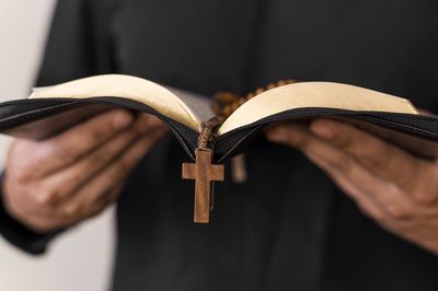 Midsection of man reading bible